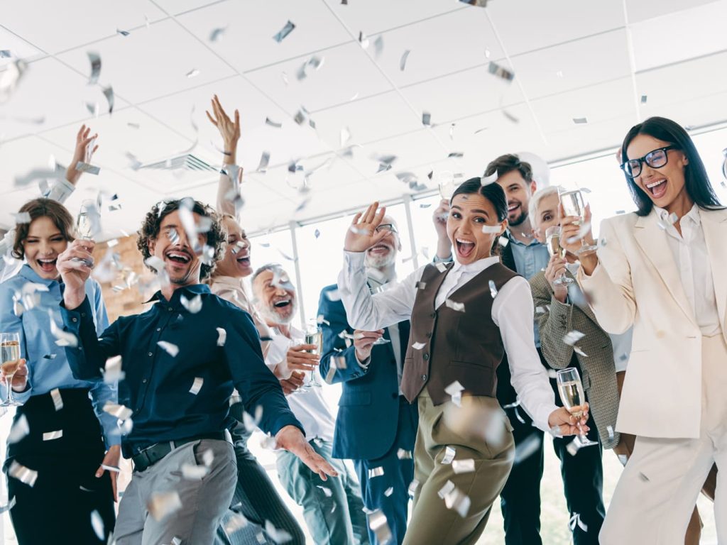 Personas celebrando en una oficina tras ganar la lotería y acercarse a la cifra para dejar de trabajar en Colombia
