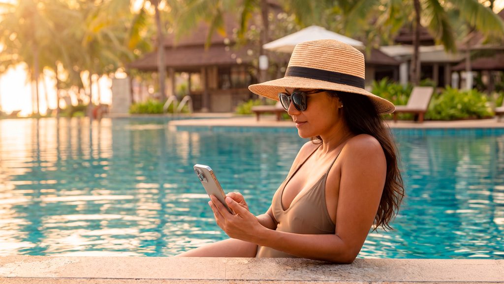 Participante del Sorteo Extraordinario de Navidad Cruz Roja consultando su celular de vacaciones